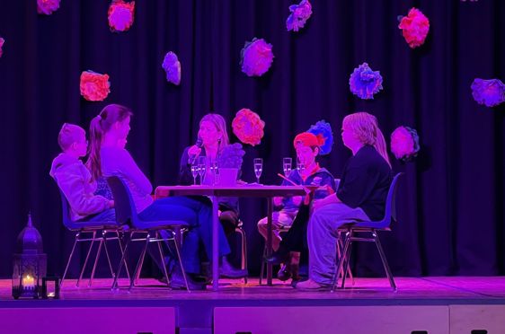 en gruppe mennesker som sitter ved et bord med en mikrofon