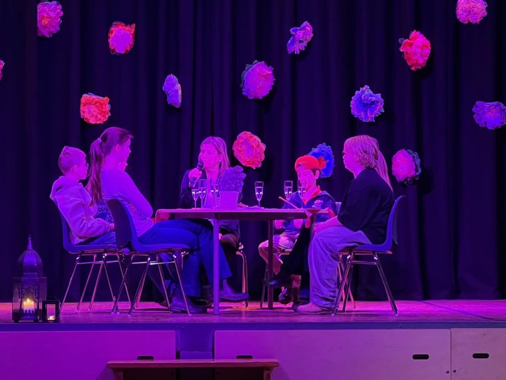 en gruppe mennesker som sitter ved et bord med en mikrofon