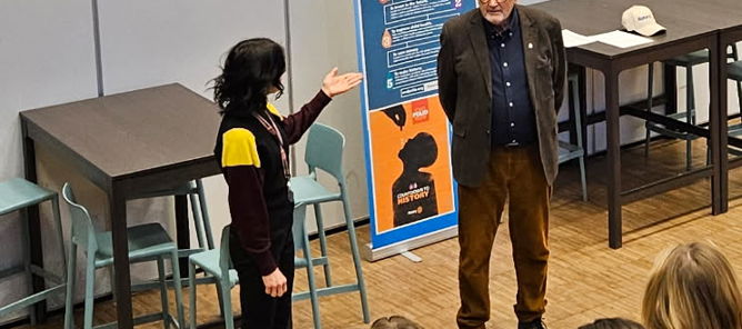 en person som står foran en gruppe mennesker